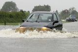 Auto, které se snaží projet zatopenou silnicí v Market Weightonu nedaleko severoanglického Hullu.
