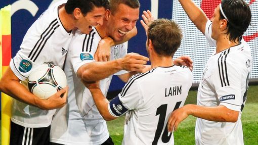 Německý fotbalista Lukas Podolski slaví se spoluhráči gól v bráně Holanďanů v utkání skupiny B na Euru 2012