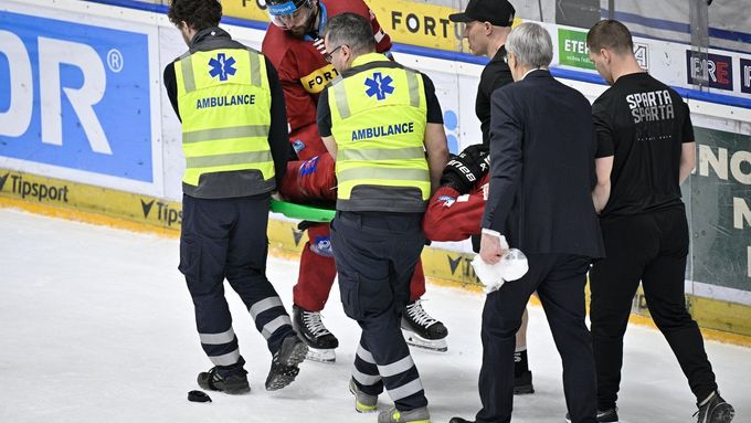 Zraněný Michal Moravčík ze Sparty opouští na nosítkách ledovou plochu.