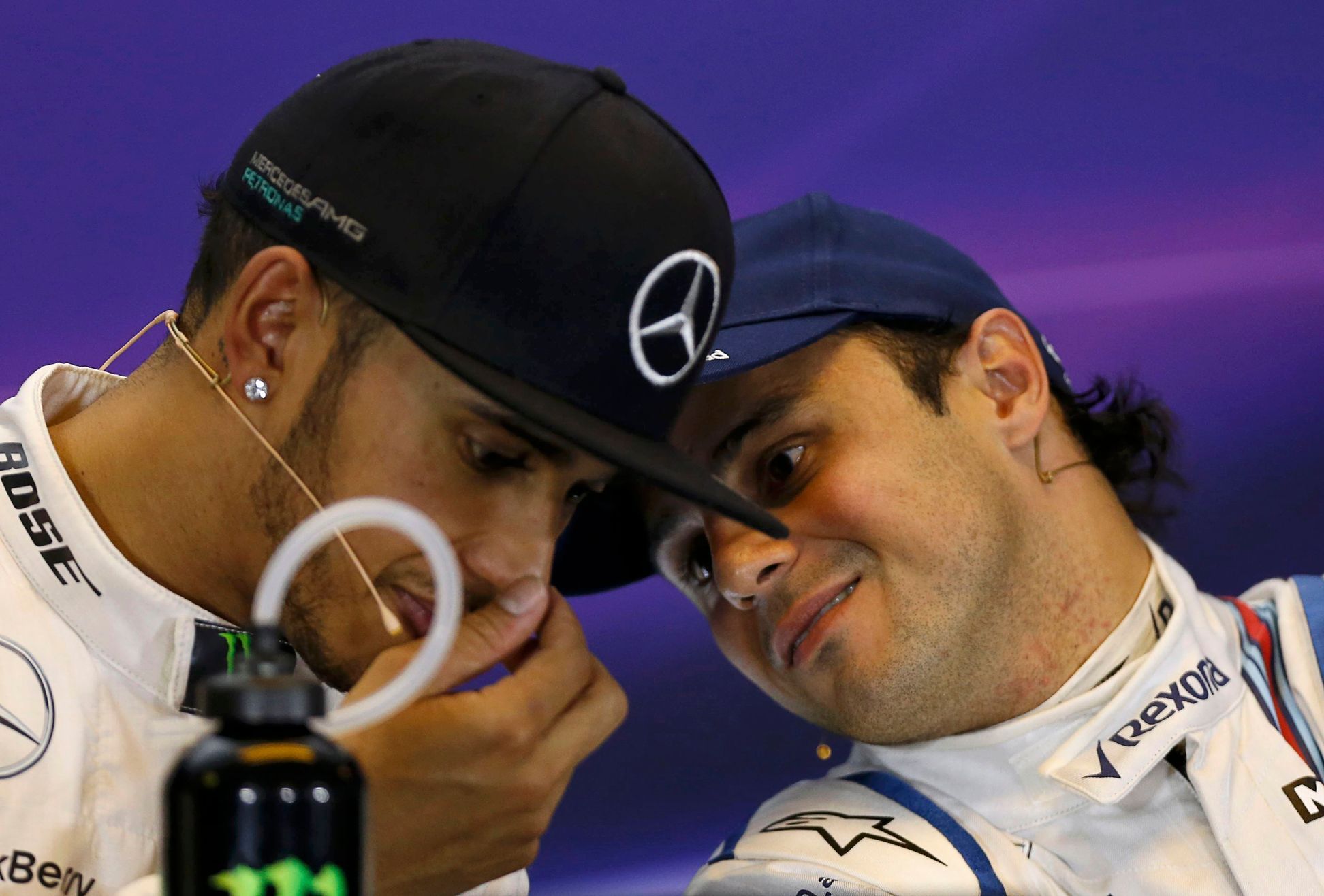Mercedes Formula One driver Nico Rosberg of Germany speaks with team mate Lewis Hamilton of Britain during a news conference following the qualifying session of the Australian F1 Grand Prix at the Alb