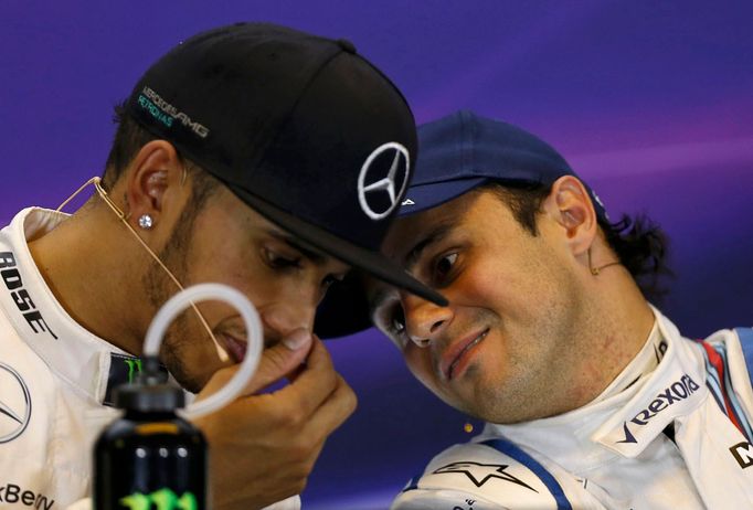 Mercedes Formula One driver Lewis Hamilton of Britain (L) speaks with Williams driver Felipe Massa of Brazil during a news conference following the qualifying session of