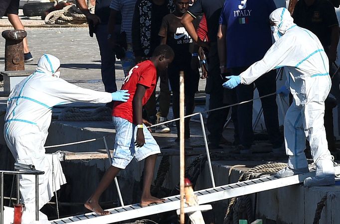 Migranti ze španělské lodi Open Arms vystupují na italském ostrově Lampedusa.