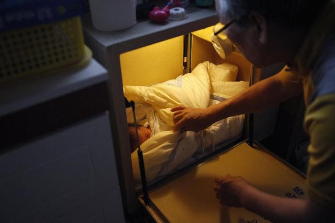 South Korean pastor Lee Jong-rak adjusts the blanket around an abandoned two-week-old baby boy in a "baby box" at Joosarang church in Seoul September 18, 2012. Lee, who runs a "baby box" where mothers can leave unwanted infants, has seen a sharp increase in the number of newborns being left there because, the pastor says, of a new law aimed protecting the rights of children. South Korea is trying to shed a reputation of being a source of babies for adoption by people abroad. It is encouraging domestic adoption and tightening up the process of a child's transfer from birth mother to adoptive parents. Picture taken September 18, 2012. REUTERS/Kim Hong-Ji (SOUTH KOREA - Tags: SOCIETY) Published: Říj. 7, 2012, 6:47 dop.