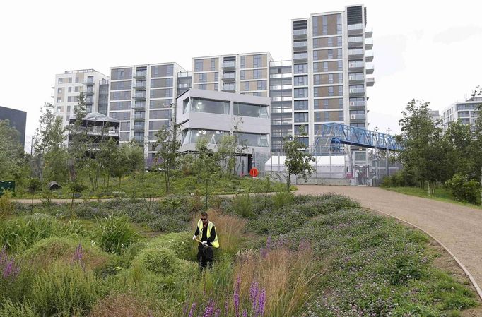 A landscape gardener works outside the Olympic Village at the Olympic Park in Stratford, the location of the London 2012 Olympic Games, in east London July 18, 2012. REUTERS/Suzanne Plunkett (BRITAIN - Tags: SPORT OLYMPICS) Published: Čec. 18, 2012, 2:30 odp.