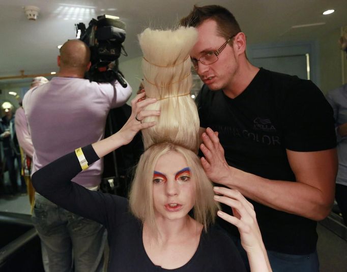 A model works with a hair stylist for Dmitri Vinokurov backstage at the 30th anniversary of the Alternative Hair Show at the Royal Albert Hall in London October 14, 2012. REUTERS/Olivia Harris (BRITAIN - Tags: SOCIETY FASHION) Published: Říj. 15, 2012, 2:10 dop.