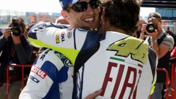 Jezdec Yamahy v MotoGP Valentino Rossi se objímá s týmovým kolegou Colinem Edwardsem (vlevo) při oslavě vítězství v kvalifikaci na Velkou cenu Turecka.