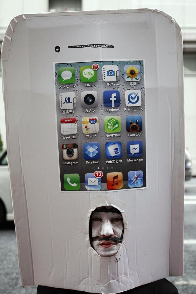 An iPhone fan waits outside an Apple Store to purchase Apple Inc's iPhone 5 in Tokyo's Ginza district September 21, 2012. Apple Inc's iPhone 5 hit stores around the globe on Friday, with fans snapping up the device that is expected to fuel a huge holiday quarter for the consumer giant. REUTERS/Yuriko Nakao (JAPAN - Tags: BUSINESS SCIENCE TECHNOLOGY TPX IMAGES OF THE DAY) Published: Zář. 21, 2012, 2:01 dop.