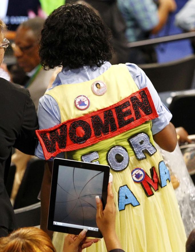 A delegate's face is reflected in her Ipad as she shoots a picture of a fellow delegate during the first session of the Democratic National Convention in Charlotte, North Carolina, September 4, 2012. REUTERS/Chris Keane (UNITED STATES - Tags: POLITICS ELECTIONS) Published: Zář. 4, 2012, 11:10 odp.