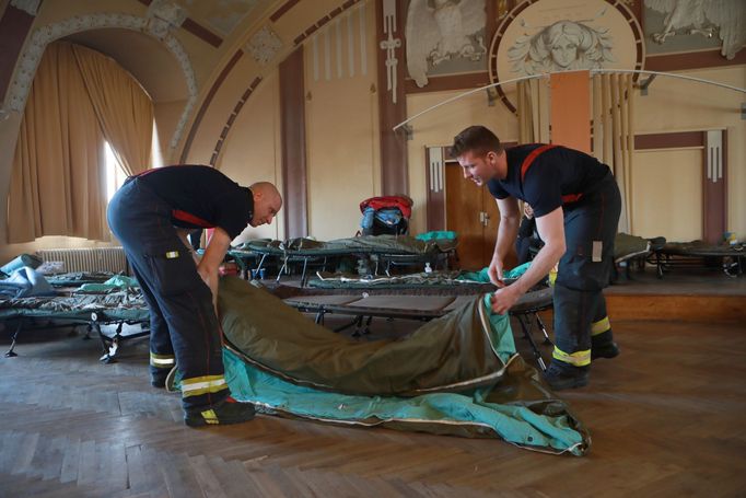 Pohled na hasiče, kteří pomáhají v uprchlickém centru v budově Správy železnic na Hlavním nádraží v Praze, kde nacházejí útočiště lidé prchající před válkou na Ukrajině..