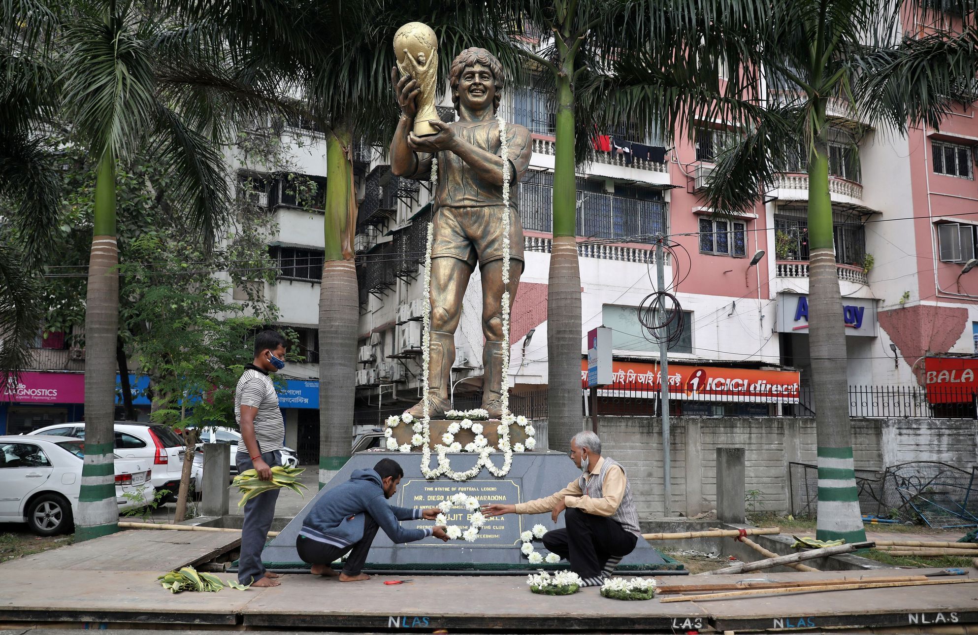 People decorate a statue of Argentine soccer great Diego Maradona before a prayer meeting, in Kolkata