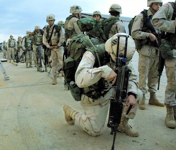 PFC Mario Nararrete takes a moment to pray while waiting to be processed and later board a plane for Kuwait at Warner Robins Air Force Base in Warner Robins, GA, 10 January, 2003. Some 500 US troops shipped out of here, part of a contingent of thousands reinforcing those in the Gulf region preparing for a possible war with Iraq. The soldiers are among some 4,000 sent to the region this week. They will meet up with two other US military brigades for a total of some 16,000 troops near what could be the front lines in a US-led invasion of Iraq. The soldiers belong to a combat division, which uses tanks and personnel carriers to move quickly across the battlefield. AFP PHOTO Steve SCHAEFER