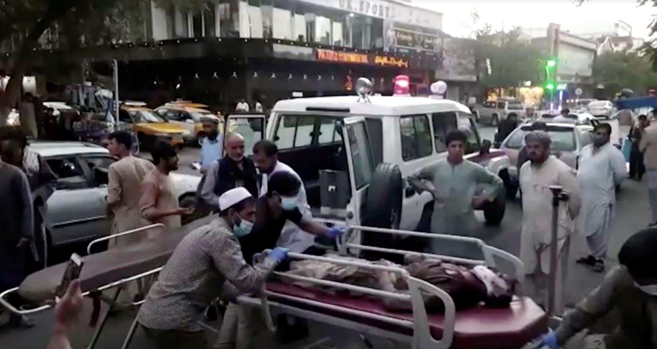 Záchranáři odnášejí muže, zraněného při čtvrtečním ruském bombardování Záporoží. Tři lidí zahynuli.