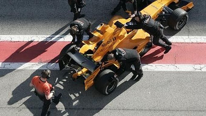 Technici tlačí do garáže nový monopost s označením MP4-21 stáje McLaren-Mercedes.