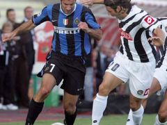 Fotbalista Interu Milán Luis Figo (vlevo) a obránce Udinese Andrea Dossena bojují o míč.