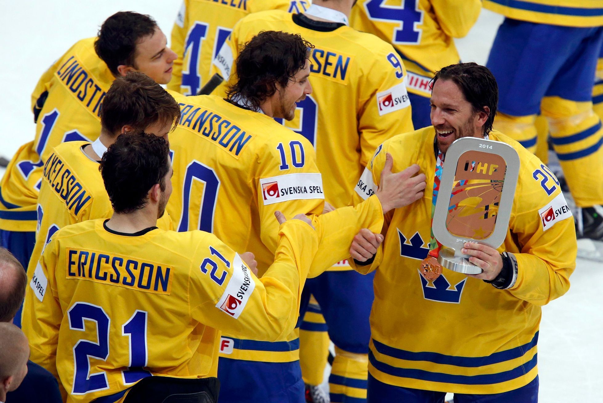 Sweden's Lundqvist holds the third place trophy as players celebrate their victory against the Czech Republic after their men's ice hockey World Championship bronze medal game at Minsk Arena in Minsk