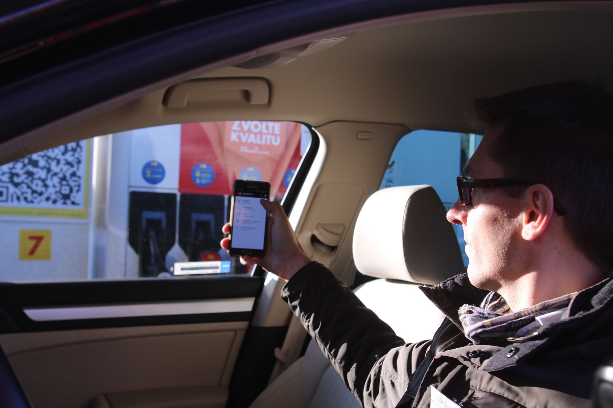 Shell platba v autě s mobilem v ruce