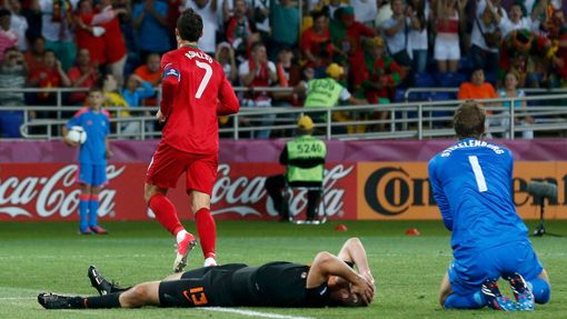 Holandský fotbalista Ron Vlaar sklesle leží po gólu odbíhajícího Portugalce Cristiana Ronalda a vedle něj klečí brankář Maarten Stekelenburg v utkání skupiny B na Euru.