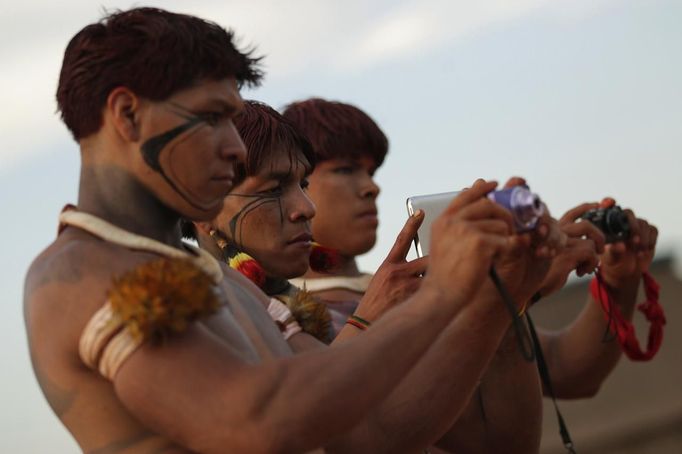 Yawalapiti men use digital cameras to record this year's 'quarup,' a ritual held over several days to honour in death a person of great importance to them, in the Xingu National Park, Mato Grosso State, August 15, 2012. This year the Yawalapiti tribe honoured two people - a Yawalapiti Indian who they consider a great leader, and Darcy Ribeiro, a well-known author, anthropologist and politician known for focusing on the relationship between native peoples and education in Brazil. Picture taken August 15, 2012. REUTERS/Ueslei Marcelino (BRAZIL - Tags: SOCIETY ENVIRONMENT) FOR EDITORIAL USE ONLY. NOT FOR SALE FOR MARKETING OR ADVERTISING CAMPAIGNS. ATTENTION EDITORS - PICTURE 26 OF 37 FOR THE PACKAGE 'THE YAWALAPITI QUARUP RITUAL' Published: Srp. 29, 2012, 10:21 dop.