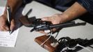 A Los Angeles County Sheriff's volunteer catalogues guns being traded in at the 'Gifts for Guns' gun buyback in Compton, California, January 21, 2013. People can trade in their guns anonymously and with no questions asked in exchange for $200 gift cards for assault weapons, $100 gift cards for shotguns, handguns and rifles, and $50 for non-operational firearms. U.S. President Barack Obama is pushing to address controversial issues surrounding gun violence and regulation as he begins his second term in office. REUTERS/David McNew (UNITED STATES - Tags: POLITICS SOCIETY) Published: Led. 21, 2013, 10:43 odp.