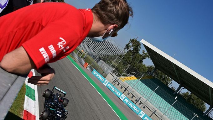 Pilot Ferrari Sebastian Vettel sleduje, jak Lewis Hamilton v Mercedesu víětzí v kvalifikaci na Velkou cenu Itálie formule 1 2020