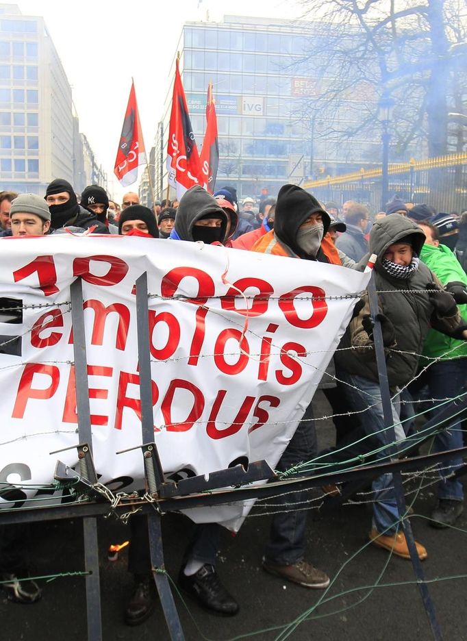 Arcelor Mittal workers from Liege hold a banner reading "10,000 jobs lost" during a demonstration outside Prime Minister Elio Di Rupo's office, where a political meeting is taking place, in Brussels January 25, 2013. ArcelorMittal the world's largest steel producer, plans to shut a coke plant and six finishing lines at its site in Liege Belgium, affecting 1,300 employees, the group said on Thursday. REUTERS/Yves Herman (BELGIUM - Tags: BUSINESS CIVIL UNREST EMPLOYMENT) Published: Led. 25, 2013, 1 odp.