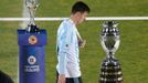 Argentina's Lionel Messi walks with his silver medal past the Copa America trophy during the presentation ceremony after Chile defeated his team in the Copa America 2015