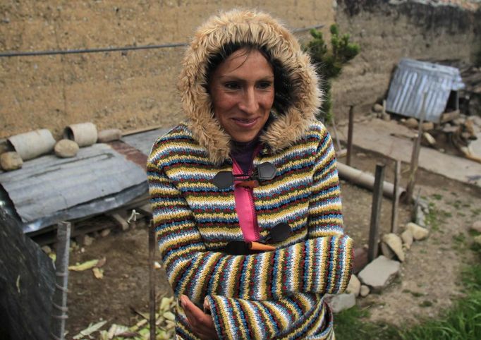 Marathon runner, Gladys Tejeda, the first Peruvian athlete who qualified for the 2012 London Olympic Games, protects against the cold at her home in the Andean province of Junin May 13, 2012. A private company will take Gladys' mother Marcelina Pucuhuaranga, 69, to London as part of the "Thank you Mom" program. For Pucuhuaranga, who received her first passport, it will be the first time travelling out of Peru. The program will take about 120 mothers of different athletes around the world to attend the games. Tejeda, the youngest of nine children, returned to her hometown to visit her mother and to focus on training where she will run more than 20 km every day in the highlands (over 4,105 meters above sea level). Picture taken May 13, 2012. REUTERS/Pilar Olivares(PERU - Tags: SPORT ATHLETICS OLYMPICS) Published: Kvě. 17, 2012, 6:16 odp.