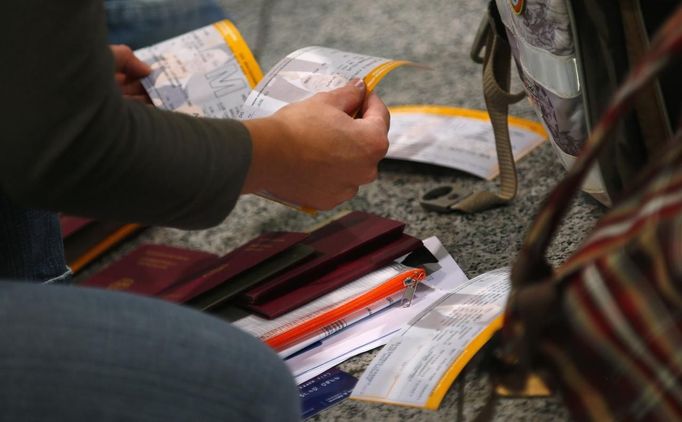 A passenger sorts tickets for German air carrier Lufthansa at the Fraport airport in Frankfurt, August 31, 2012. Lufthansa passengers face widespread flight disruption from Friday after cabin crew representatives said they would start a series of strikes over pay and cost-cutting measures at Germany's largest airline. The UFO union, which represents around two-thirds of Lufthansa's 19,000 cabin crew, late on Thursday called on its members to strike from 0300 GMT to 1100 GMT on Friday in Frankfurt. REUTERS/Kai Pfaffenbach (GERMANY - Tags: BUSINESS EMPLOYMENT CIVIL UNREST TRANSPORT) Published: Srp. 31, 2012, 4:37 dop.