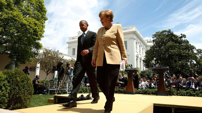 Barack Obama a Angela Merkelová odcházejí z tiskové konference před Bílým domem.