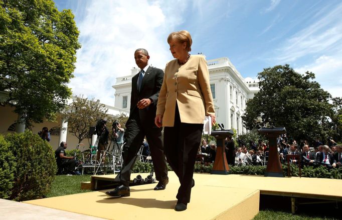 Barack Obama a Angela Merkelová odcházejí z tiskové konference před Bílým domem.