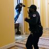 Policista zasahuje proti demonstrantovi Kapitol