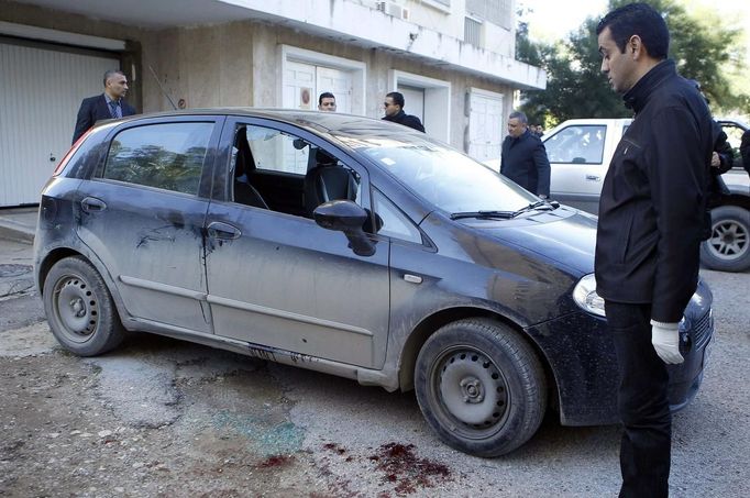 A forensic inspector (R) looks at the car of prominent Tunisian opposition politician Shokri Belaid, who was shot dead outside his home, in Tunis February 6, 2013. Belaid was shot dead outside his home on Wednesday, in a killing the prime minister condemned as a political assassination and a strike against the "Arab Spring" revolution. Prime Minister Hamadi Jebali said the identity of the killer of Belaid, a staunch secular opponent of the moderate Islamist-led government, was unknown. REUTERS/Zoubeir Souissi (TUNISIA - Tags: POLITICS CIVIL UNREST CRIME LAW) Published: Úno. 6, 2013, 12:32 odp.