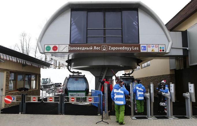 Members of the Italian free ride and snowboard team wait in front of a brand new gondola on their way to the top of the mountain at the plateau of Rosa Khutor, a venue for the Sochi 2014 Winter Olympics near Sochi February 13, 2013. Although many complexes and venues in the Black Sea resort of Sochi mostly resemble building sites that are still under construction, there is nothing to suggest any concern over readiness. Construction will be completed by August 2013 according to organizers. The Sochi 2014 Winter Olympics opens on February 7, 2014. REUTERS/Kai Pfaffenbach (RUSSIA - Tags: CITYSCAPE BUSINESS CONSTRUCTION ENVIRONMENT SPORT OLYMPICS) Published: Úno. 13, 2013, 11:07 dop.