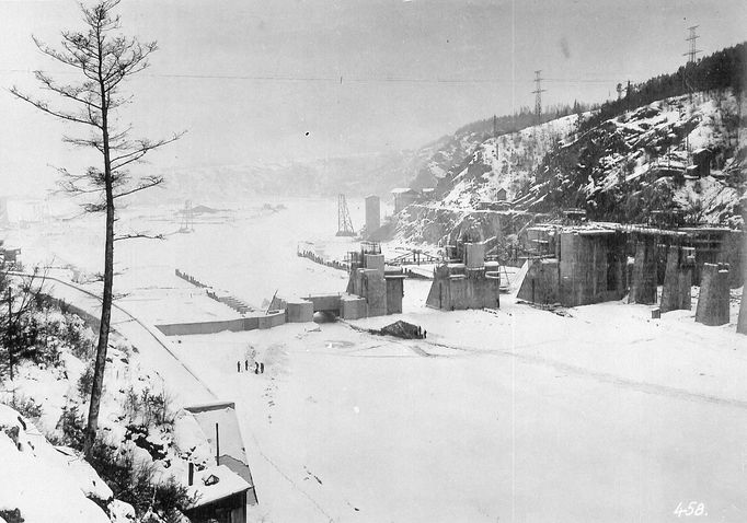 Historická fotografie zachycující výstavbu vodní nádrže Štěchovice, která probíhala mezi lety 1937 a 1944, navzdory válečným komplikacím.