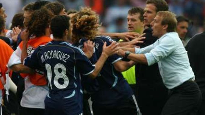 Německý kouč Klinsmann (vpravo v bílém) se snaží uklidnit šarvátku mezi hráči Německa a Argentiny po skončení jejich čtvrtfinálového zápasu.