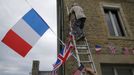 Local residents hang up flags during preparations for the 75th anniversary of the D-Day Normandy landings, in La Cambe, France, June 4, 2019. REUTERS/Pascal Rossignol