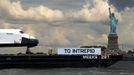 The Space Shuttle Enterprise passes the Statue of Liberty as it rides on a barge in New York harbor, June 6, 2012. The Space Shuttle Enterprise was being moved up the Hudson River to be placed at the Intrepid Sea, Air and Space Museum. REUTERS/Mike Segar (UNITED STATES - Tags: TRANSPORT SCIENCE TECHNOLOGY) Published: Čer. 6, 2012, 3:44 odp.