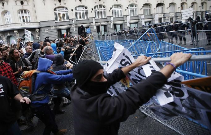 Anti-austerity demonstrators pull down a security barrier outside the the Spanish parliament in Madrid, September 25, 2012. Anti-austerity demonstrators protested in Madrid ahead of the government's tough 2013 budget that will cut into social services as the country teeters on the brink of a bailout. REUTERS/Paul Hanna (SPAIN - Tags: POLITICS CIVIL UNREST BUSINESS) Published: Zář. 25, 2012, 6:27 odp.