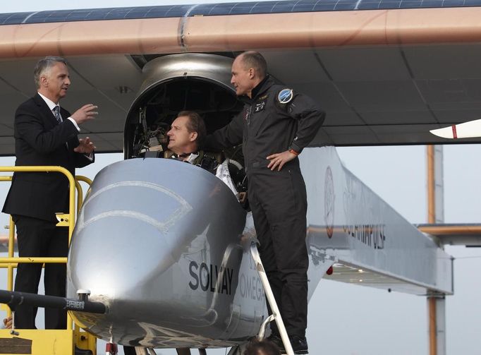 Swiss Foreign Minister Didier Burkhalter (L) gestures near Solar Impulse project president and pilot Bertrand Piccard (R) and CEO and pilot Andre Borschberg before take off at Payerne airport May 24, 2012. The Solar Impulse HB-SIA prototype aircraft, which has 12,000 solar cells built into its 64.3 metres (193 feet) wings, attempted its first intercontinental flight from Payerne to Rabat in Morocco with a few days for a technical stop and a change of pilot in Madrid. This flight will act as a final rehearsal for the 2014 round-the-world flight. REUTERS/Denis Balibouse (SWITZERLAND - Tags: TRANSPORT SCIENCE TECHNOLOGY SOCIETY POLITICS BUSINESS) Published: Kvě. 24, 2012, 7:38 dop.