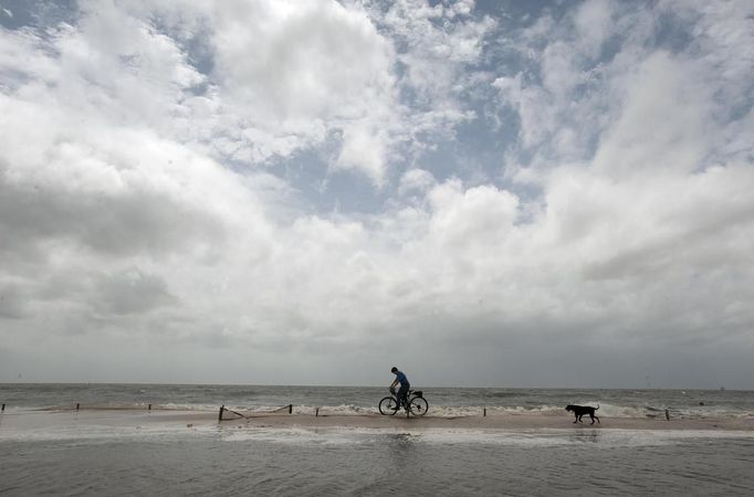 Noah Warr pushes his bicycle along the beach as Hurricane Isaac approaches Gulfport, Mississippi, August 28, 2012. REUTERS/Michael Spooneybarger (UNITED STATES - Tags: ENVIRONMENT DISASTER ANIMALS) Published: Srp. 28, 2012, 8:45 odp.