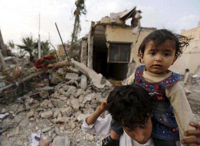 A boy carries his sister near the collapsed house of Yemen's late prime minister Faraj Bin Ghanim after it was hit by a Saudi-led air strike in Sanaa July 2, 2015. Saudi-