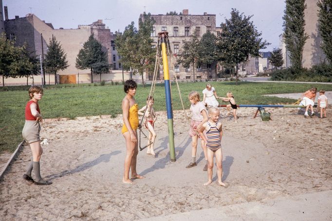 Děti si hrají na pískovišti v Kelet-Berlíně na náměstí Monbijouplatz v roce 1961. V pozadí jsou vidět typické městské budovy východního Berlína té doby.