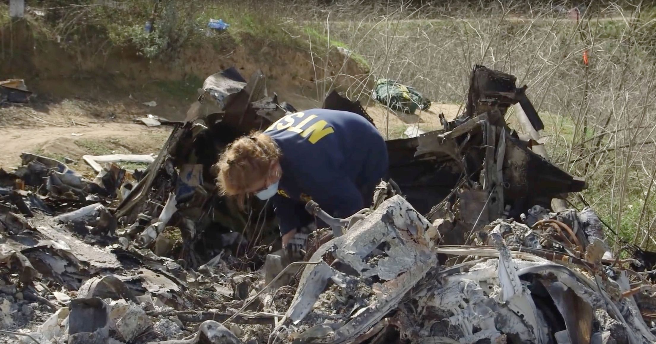 An investigator works at the site of the helicopter crash that killed Kobe Bryant and eight others in a screen grab taken in Calabasas