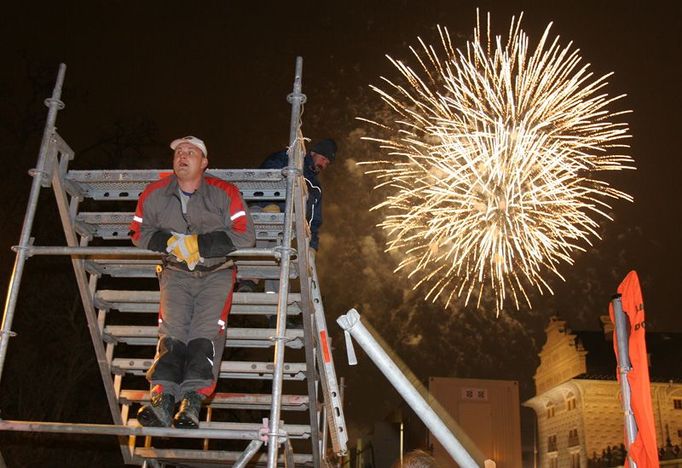 Hodina a půl po skončení závodu: nad Hradčany září předčasný silvestrovský ohňostroj, zatímco dělníci rychle rozebírají trať.