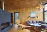 Středobodem domu je obývací pokoj s krbem, který je kombinací dubového dřeva a antracitového matného kovu.