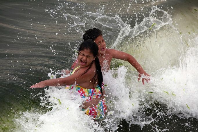 Children play in the ocean at Coney Island in the Brooklyn borough of New York June 30, 2012. Nearly 4 million homes and businesses were without power on Saturday amid a record heat wave in the eastern United States after deadly thunderstorms downed power lines from Indiana to New Jersey. REUTERS/Eric Thayer (UNITED STATES - Tags: ENVIRONMENT SOCIETY) Published: Čec. 1, 2012, 2:27 dop.