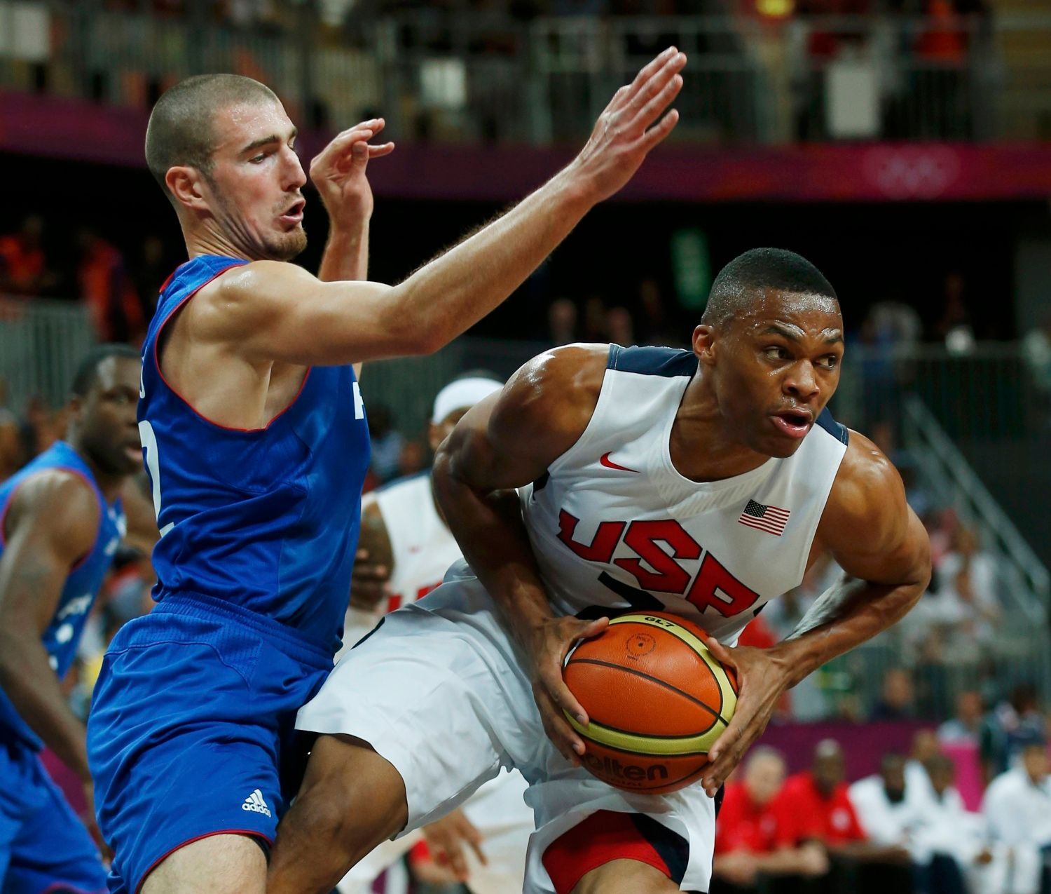 Člen amerického Dream Teamu Russell Westbrook probíhá přes Nanda de Cola v utkání základní skupiny A s Francií na OH 2012 v Londýně.