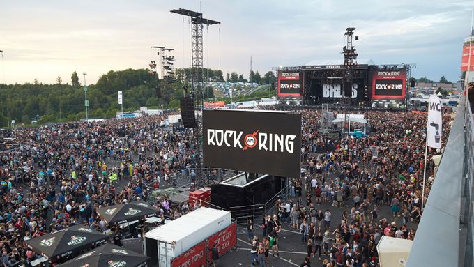 Diváci opouštějí prostor festivalu Rock am Ring v areálu automobilového závodního okruhu Nürburgring.