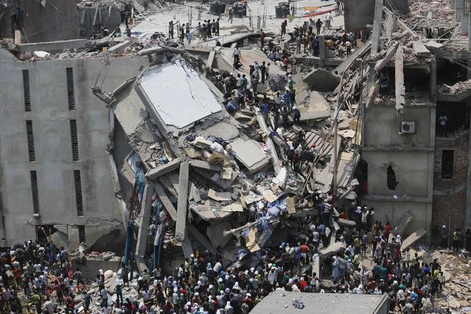 People rescue garment workers trapped under rubble at the Rana Plaza building after it collapsed, in Savar, 30 km (19 miles) outside Dhaka April 24, 2013. An eight-storey block housing garment factories and a shopping centre collapsed on the outskirts of the Bangladeshi capital on Wednesday, killing at least 25 people and injuring more than 500, the Ntv television news channel reported. REUTERS/Andrew Biraj (BANGLADESH - Tags: DISASTER BUSINESS) Published: Dub. 24, 2013, 8:07 dop.