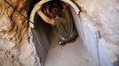 An Israeli soldier squats in a tunnel exposed by the Israeli military, just outside the southern Gaza Strip